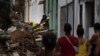 La gente observa a los bomberos limpiando los escombros de un edificio que se derrumbó parcialmente en busca de sobrevivientes en La Habana, Cuba, el 4 de octubre de 2023. (Foto AP/Ramon Espinosa)