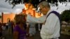 Un sacerdote bendice a un peregrino durante la procesión a El Rincón en adoración a San Lázaro. Yamil Lage/AFP