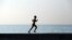 Un joven corre por el muro del malecón de La Habana.